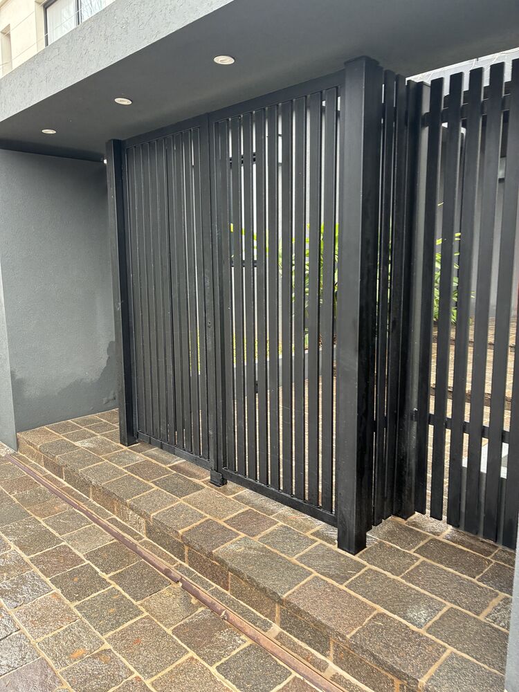 Entrada de adoquines con la reja negra, seca y limpia