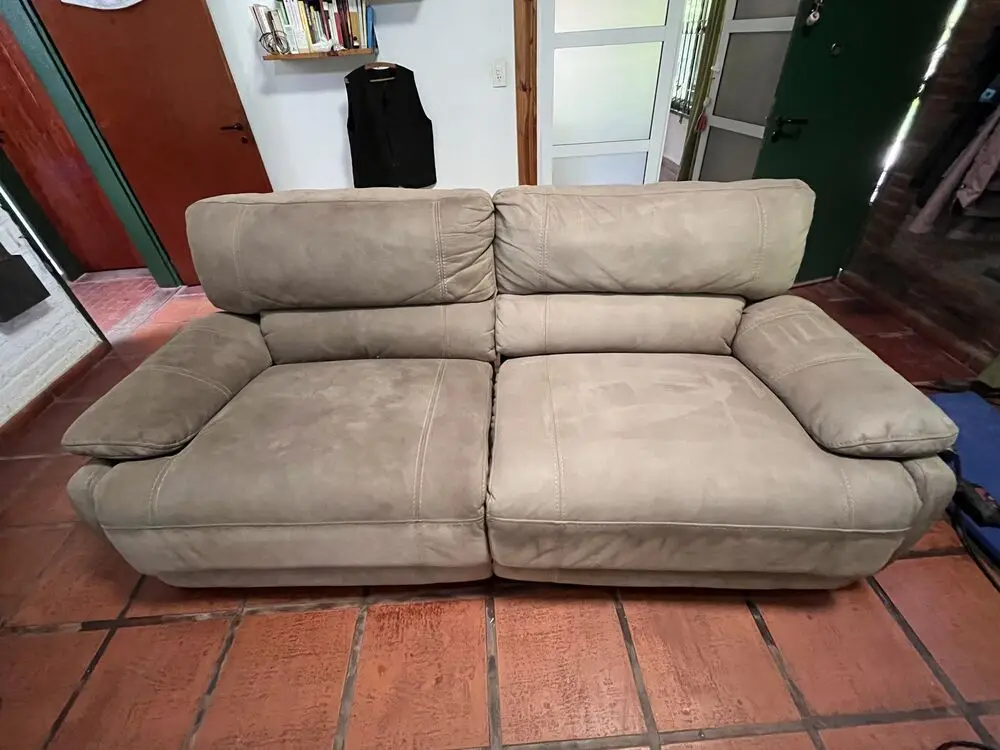 Sillón de dos cuerpos de gamuza beige, limpio, sobre piso rojo